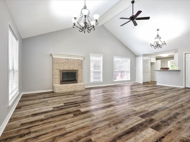 unfurnished living room featuring high vaulted ceiling, dark hardwood / wood-style floors, a fireplace, and a wealth of natural light