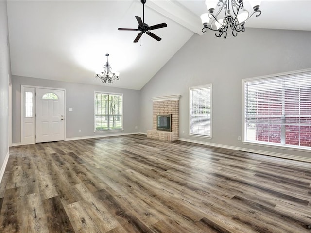 unfurnished living room featuring beam ceiling, high vaulted ceiling, wood-type flooring, a fireplace, and ceiling fan with notable chandelier