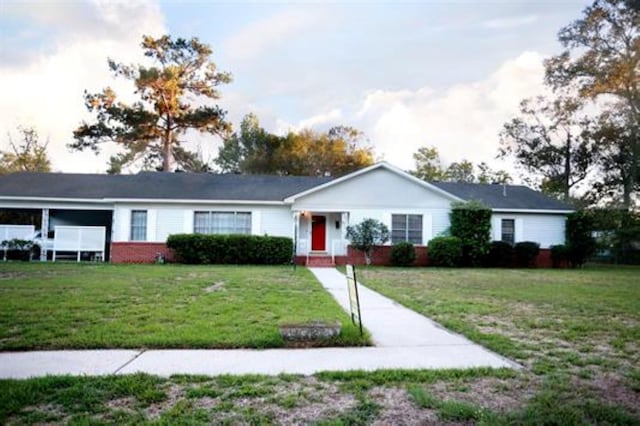 ranch-style home featuring a carport and a front lawn