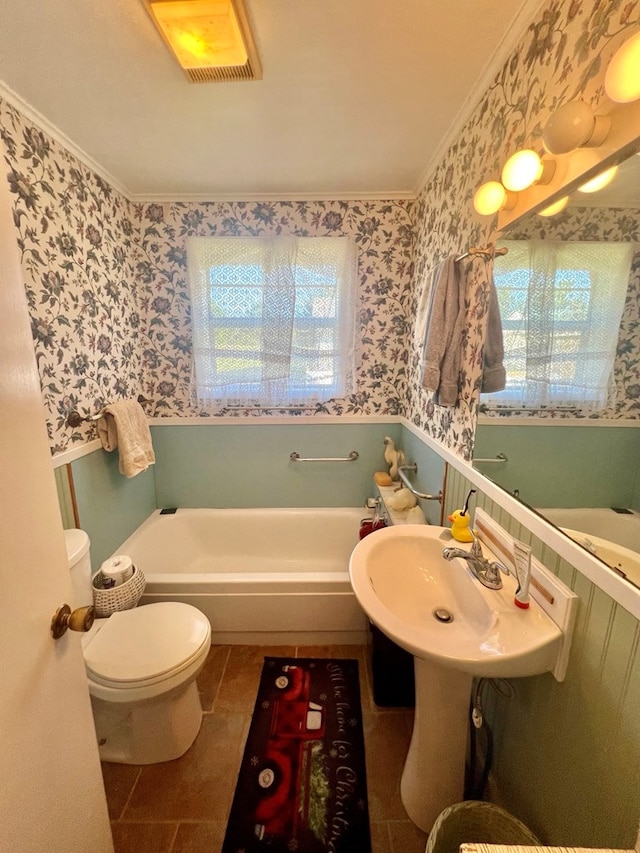 bathroom featuring tile patterned floors, a tub to relax in, crown molding, and a healthy amount of sunlight