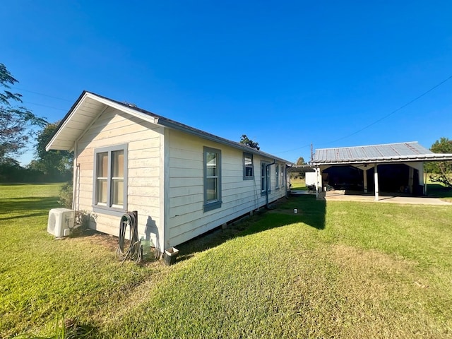 view of side of property featuring ac unit and a yard