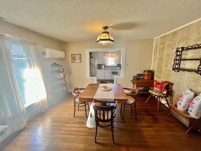 dining space with a wall unit AC, hardwood / wood-style floors, and a textured ceiling