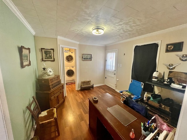 office area with ornamental molding, stacked washing maching and dryer, and hardwood / wood-style flooring