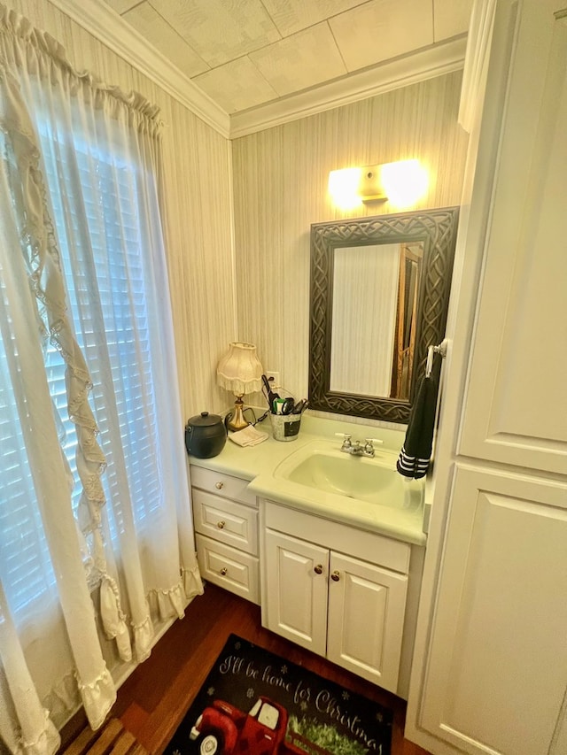 bathroom featuring vanity, wood-type flooring, and ornamental molding