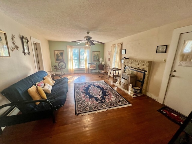 living room with ceiling fan, dark hardwood / wood-style flooring, and a textured ceiling