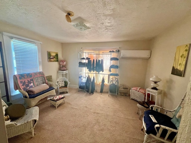 sitting room with a wall mounted AC, carpet floors, and a textured ceiling