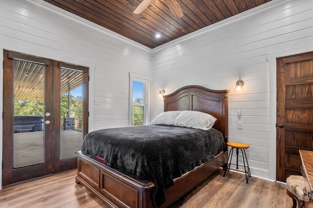 bedroom with wooden walls, wooden ceiling, access to outside, and light hardwood / wood-style flooring