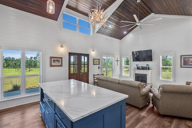 kitchen with a healthy amount of sunlight, wooden ceiling, blue cabinetry, and high vaulted ceiling