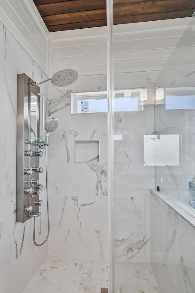 bathroom with tiled shower and a wealth of natural light