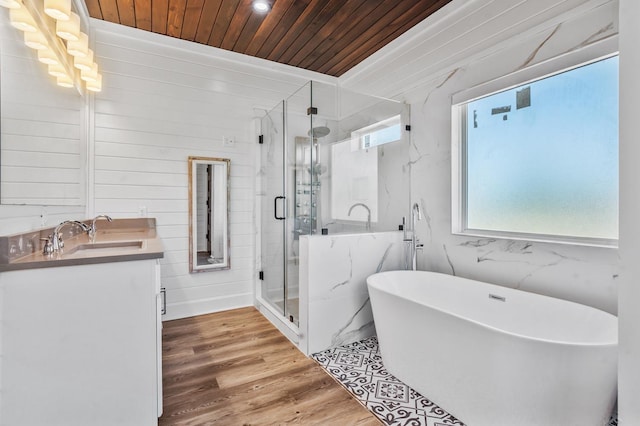 bathroom with plus walk in shower, hardwood / wood-style floors, vanity, and wooden ceiling