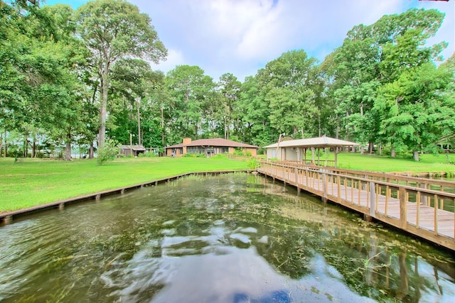 dock area with a lawn and a water view