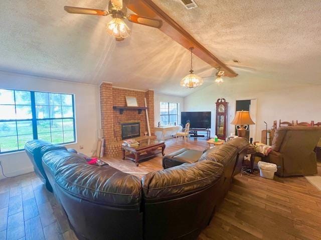 living room with lofted ceiling with beams, a fireplace, wood-type flooring, and a textured ceiling