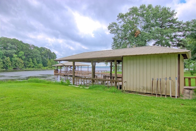 view of dock with a water view and a yard