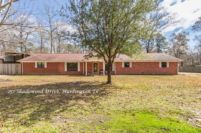 ranch-style home with a front lawn, fence, and brick siding