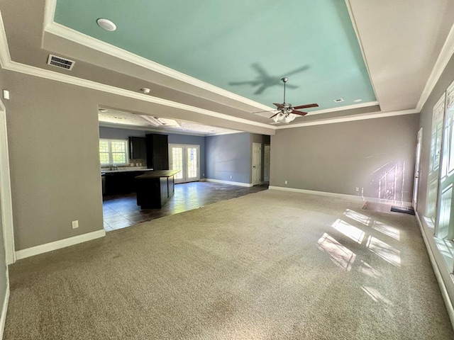 2505 County Road 4420, Spurger, TX 77660 - unfurnished living room featuring a tray ceiling, carpet floors, baseboards, crown molding, and ceiling fan