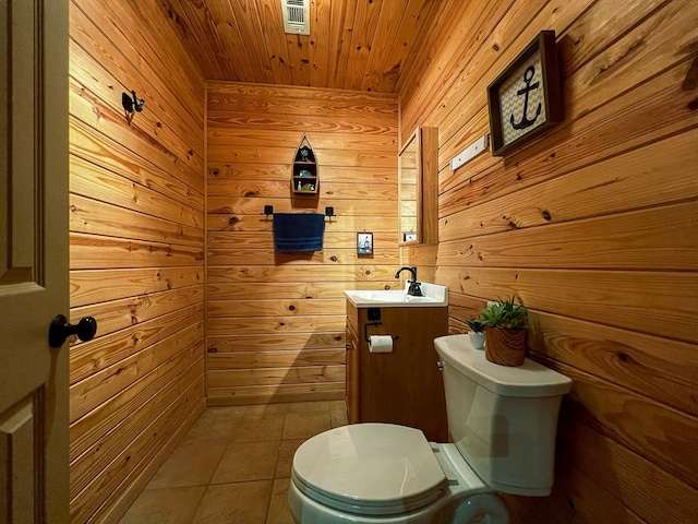 bathroom with wood walls, tile patterned flooring, and toilet