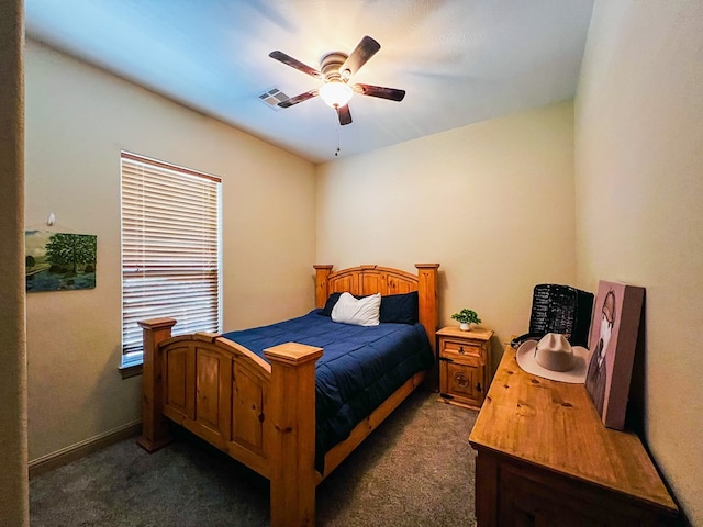 bedroom with dark carpet, visible vents, and a ceiling fan