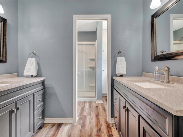 bathroom featuring a shower, wood-type flooring, and vanity