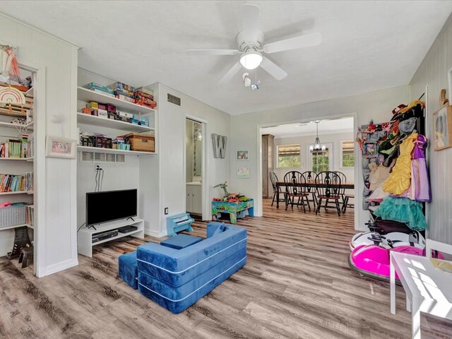 living room featuring hardwood / wood-style floors and ceiling fan with notable chandelier