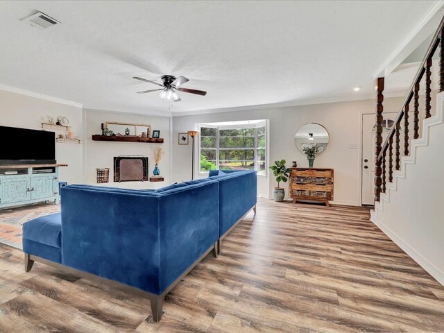 living room with hardwood / wood-style floors, ceiling fan, and crown molding