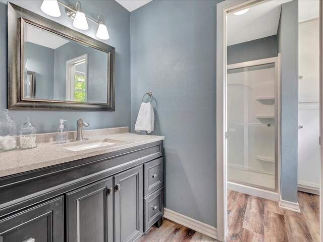 bathroom featuring hardwood / wood-style floors, vanity, and walk in shower