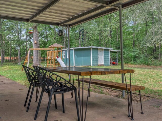 view of patio / terrace with a playground and a storage shed