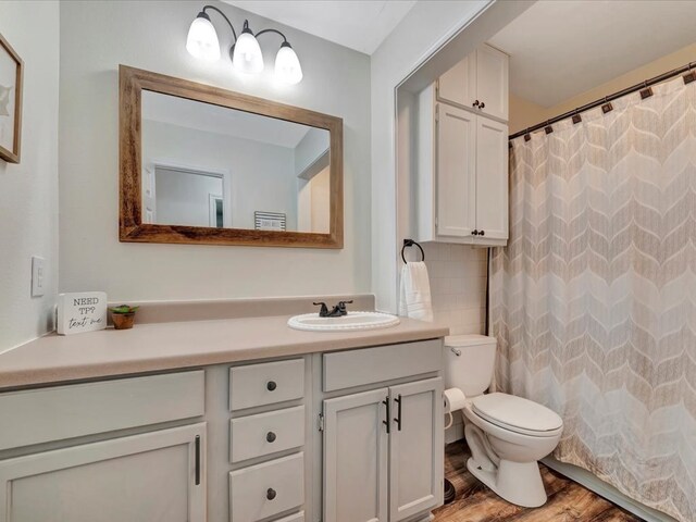 bathroom with hardwood / wood-style floors, vanity, a shower with curtain, decorative backsplash, and toilet