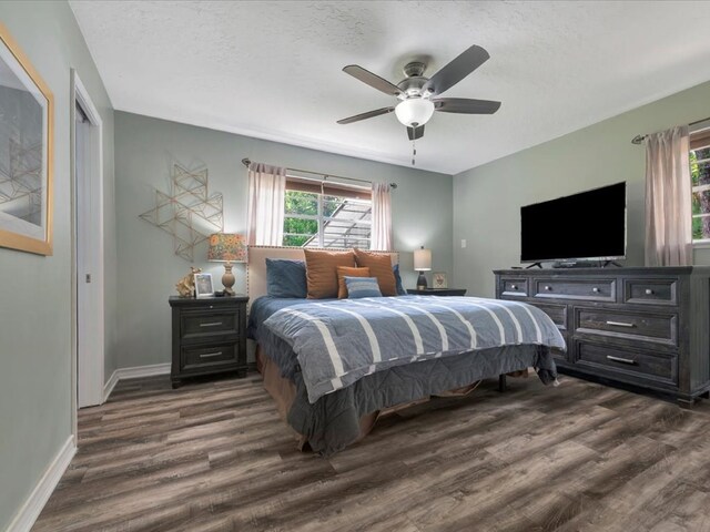 bedroom featuring ceiling fan, dark wood-type flooring, and a textured ceiling