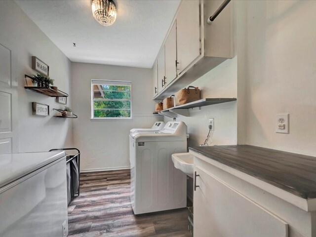 laundry room with cabinets, independent washer and dryer, and dark wood-type flooring