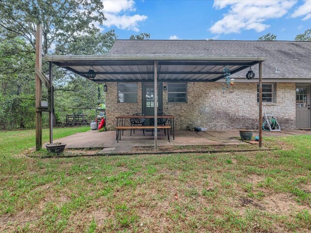 back of property featuring a lawn and a patio