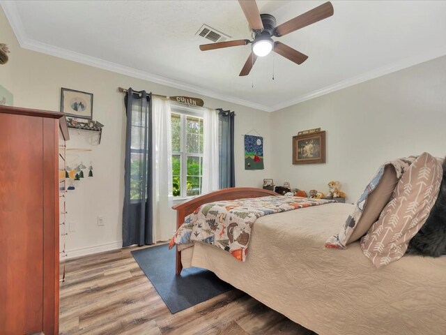 bedroom with hardwood / wood-style flooring, ceiling fan, and crown molding