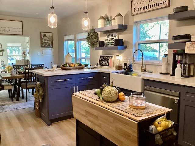 kitchen featuring pendant lighting, light wood-type flooring, and sink