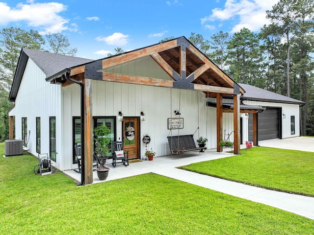 exterior space featuring central AC unit, a garage, and a front lawn