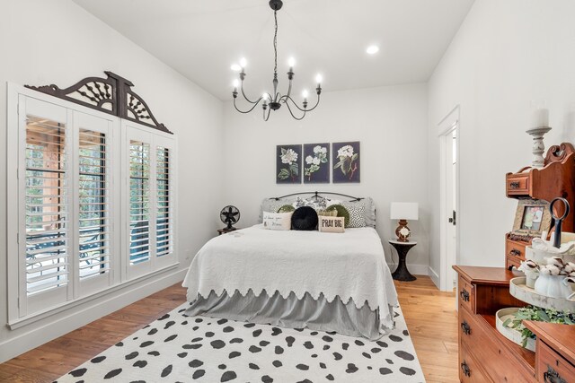 bedroom with a notable chandelier and light hardwood / wood-style floors