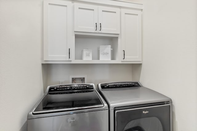 laundry room featuring cabinets and washing machine and dryer