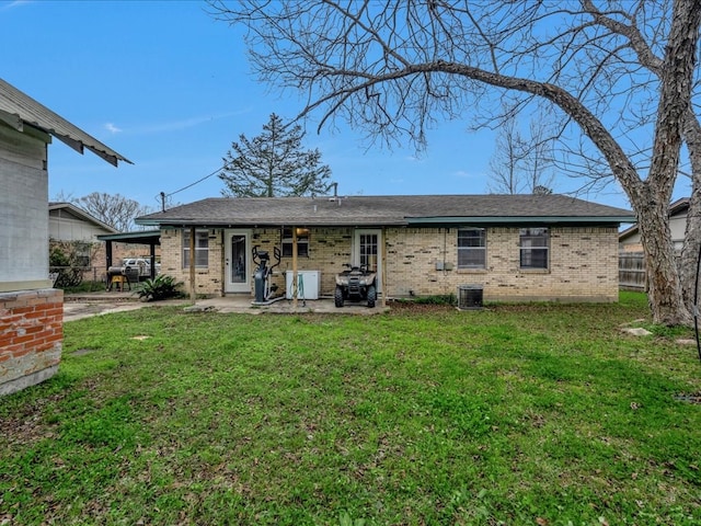 rear view of property with a lawn, a patio area, and central air condition unit