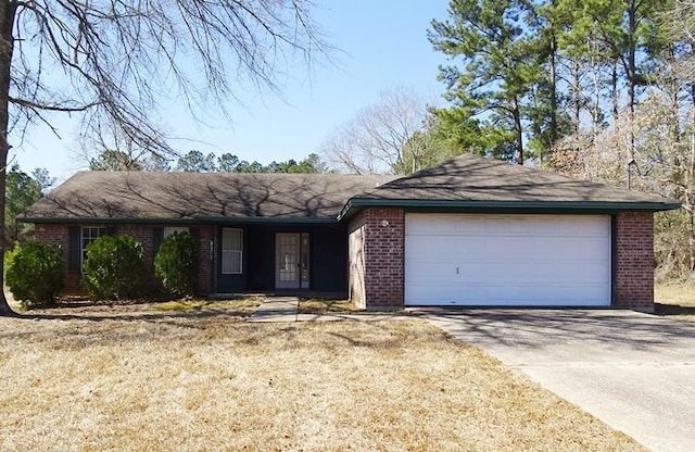 ranch-style home featuring a garage, a front yard, brick siding, and driveway