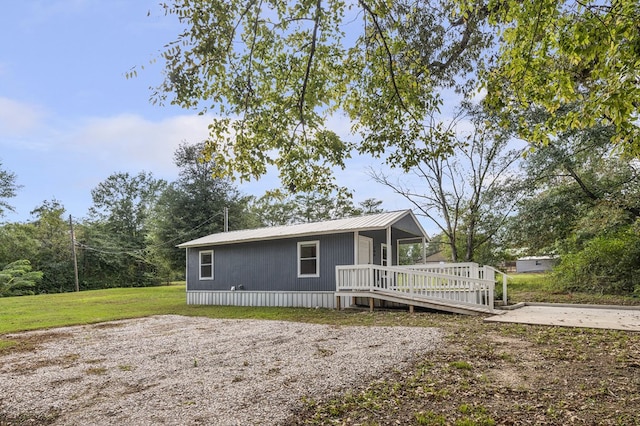 exterior space featuring a wooden deck and a front lawn