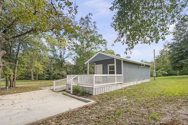 view of side of home with a porch and a lawn