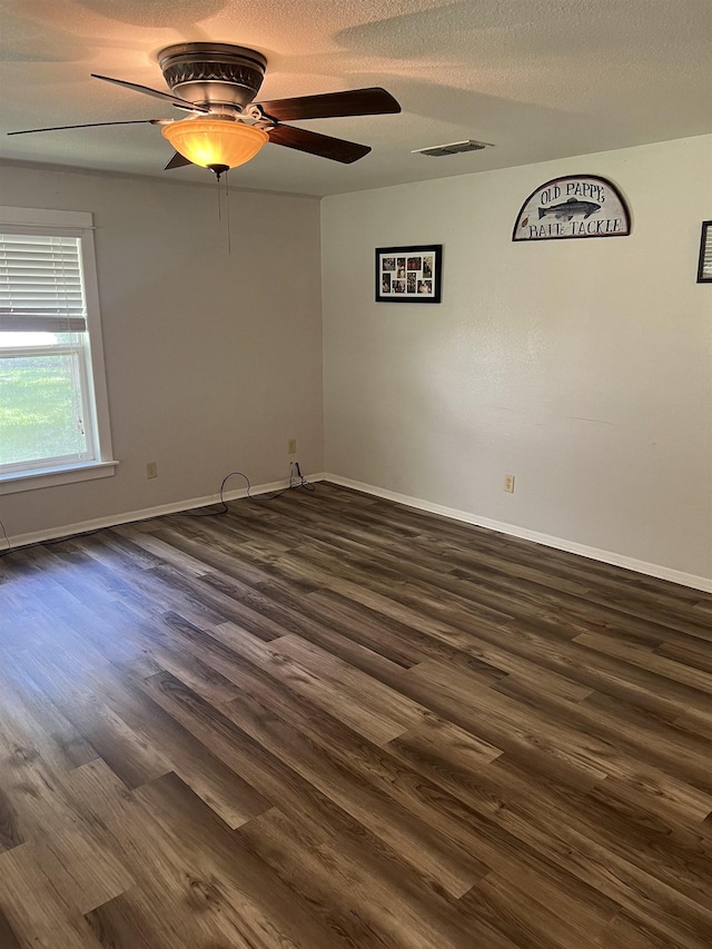 unfurnished room featuring ceiling fan, dark wood-type flooring, and a textured ceiling