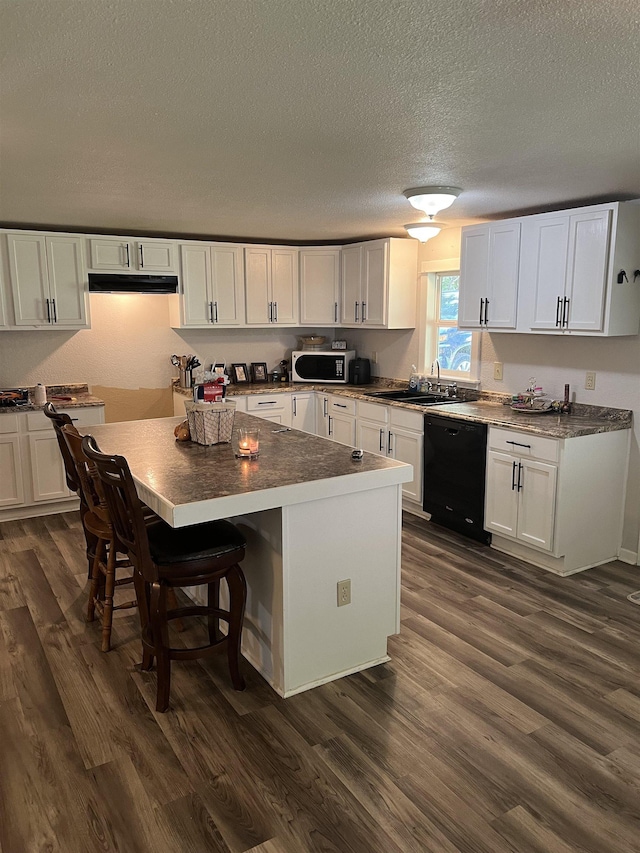 kitchen with dark hardwood / wood-style flooring, dishwasher, white cabinets, and sink