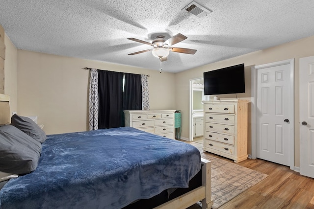 920 Richardson Dr, Jasper, TX 75951 - bedroom with light wood-style floors, a textured ceiling, and a ceiling fan