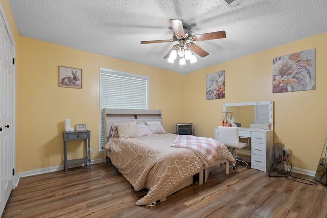 920 Richardson Dr, Jasper, TX 75951 - bedroom with wood finished floors, baseboards, a closet, a textured ceiling, and ceiling fan