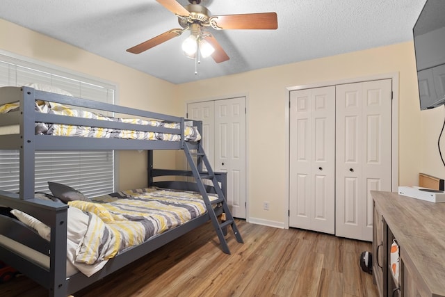 920 Richardson Dr, Jasper, TX 75951 - bedroom featuring light wood finished floors, two closets, baseboards, a ceiling fan, and a textured ceiling
