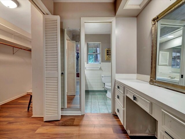 bathroom with vanity, hardwood / wood-style flooring, toilet, and tile walls