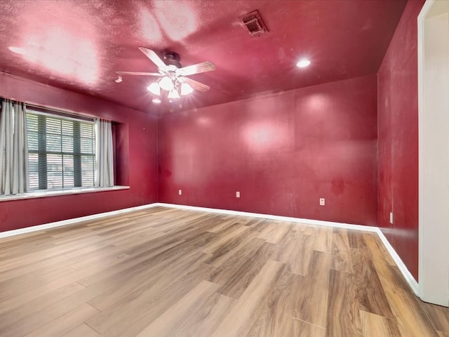 unfurnished room featuring ceiling fan, light hardwood / wood-style floors, and a textured ceiling