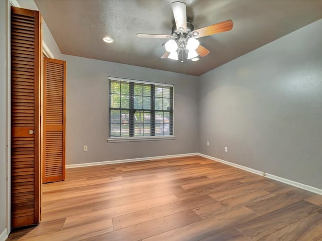 unfurnished bedroom featuring light wood-type flooring, a closet, and ceiling fan