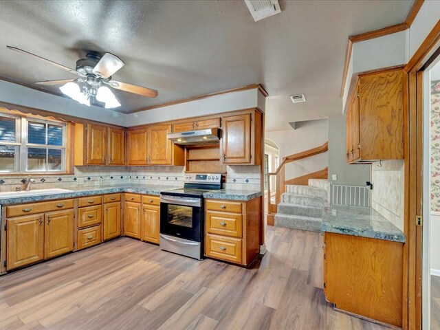 kitchen featuring decorative backsplash, light wood-type flooring, ceiling fan, sink, and electric range