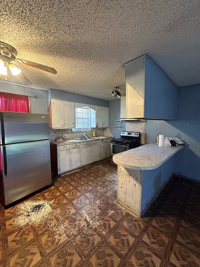 kitchen with range with electric stovetop, light countertops, freestanding refrigerator, and a peninsula