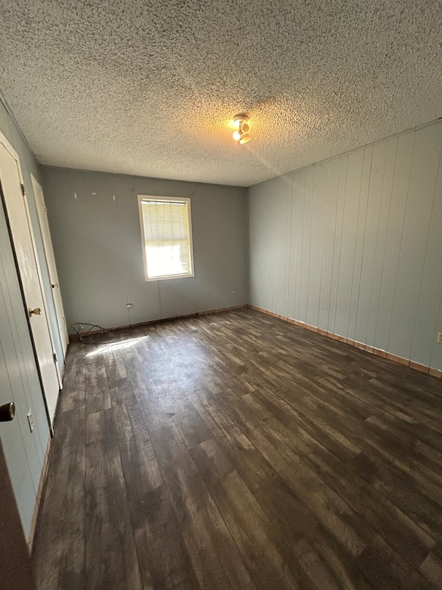 unfurnished bedroom with a textured ceiling and wood finished floors